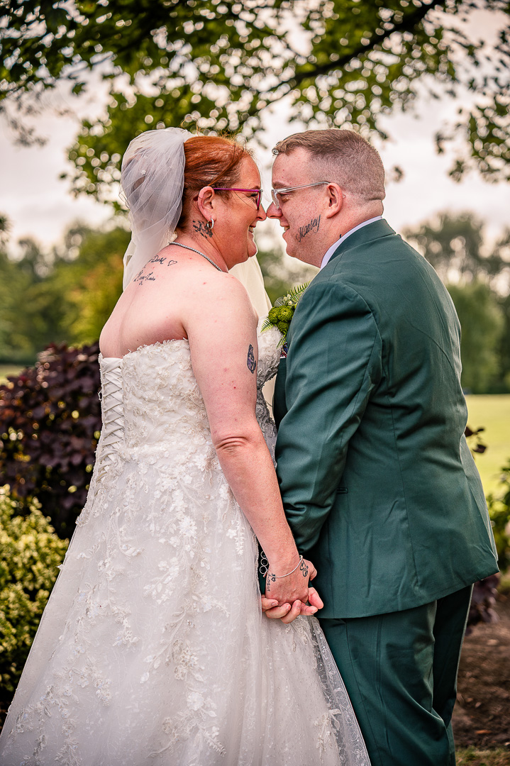 Bride and groom touching noses during their portraits at Broadfield Park