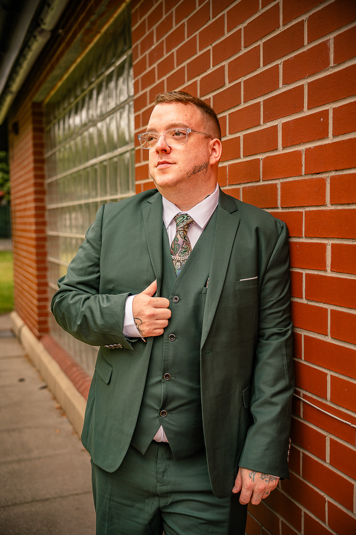 Groom leaning against a stone well during morning preparations at the Royal Toby Hotel
