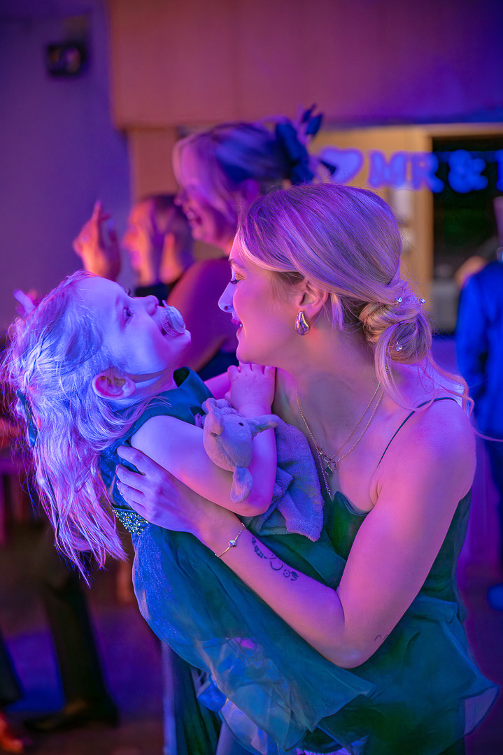 Mother holding her young daughter while facing each other on the dance floor at Bucks Bar during a classic family-focused wedding