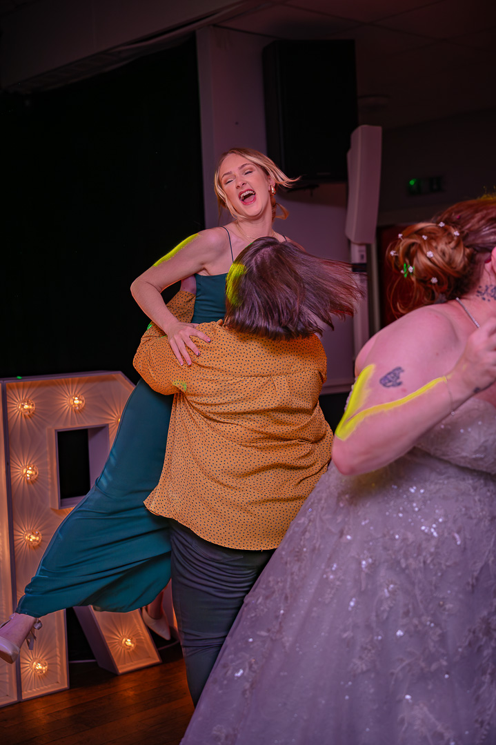 Guest lifting another woman into the air during dancing at Bucks Bar reception, celebrating the couple’s elegant, joyful wedding day
