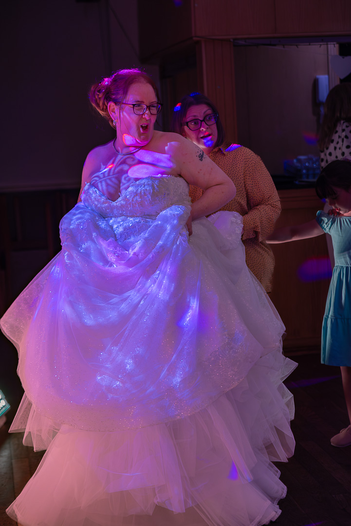 Bride dancing gracefully while holding up her wedding dress at Bucks Bar during her elegant, traditional wedding celebration