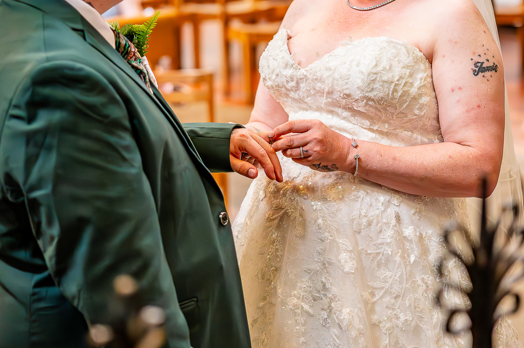 Close-up of the bride placing the wedding ring on the groom’s hand