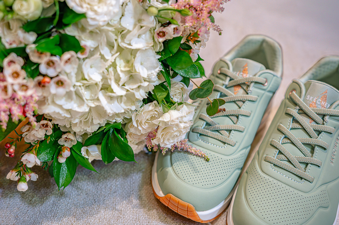Bride’s green wedding trainers beside her bouquet during morning preparations at the Royal Toby Hotel for a traditional, Christian wedding