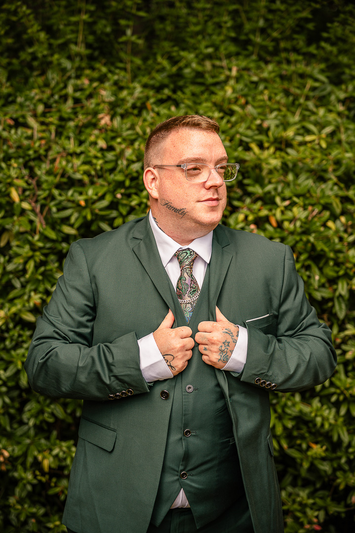 Groom holding his suit jacket outside the Royal Toby Hotel before the ceremony of their classic wedding day
