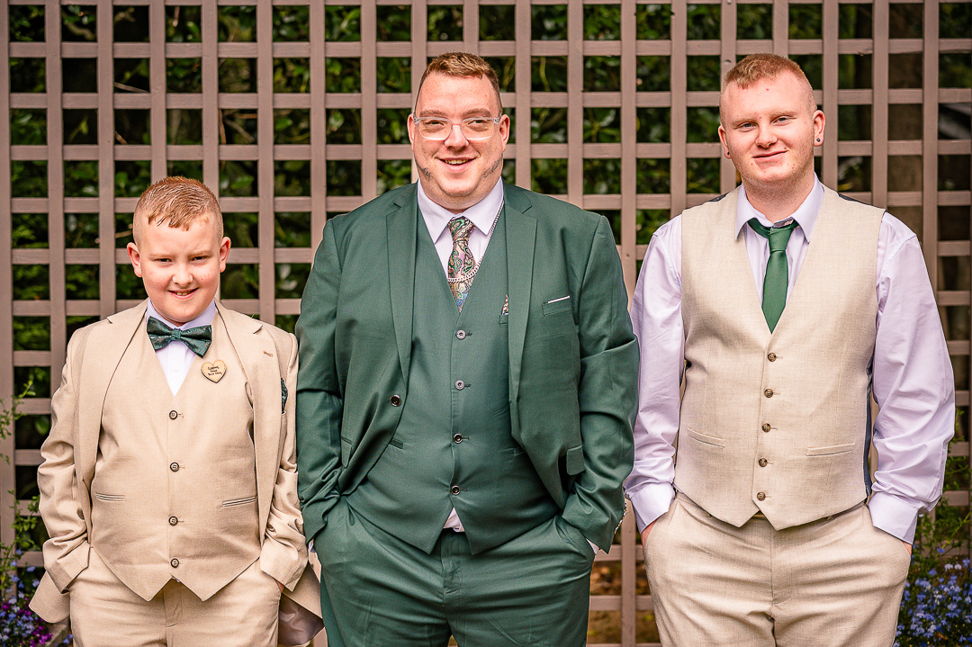 Groom with his two young groomsmen sharing a relaxed moment before leaving for the ceremony