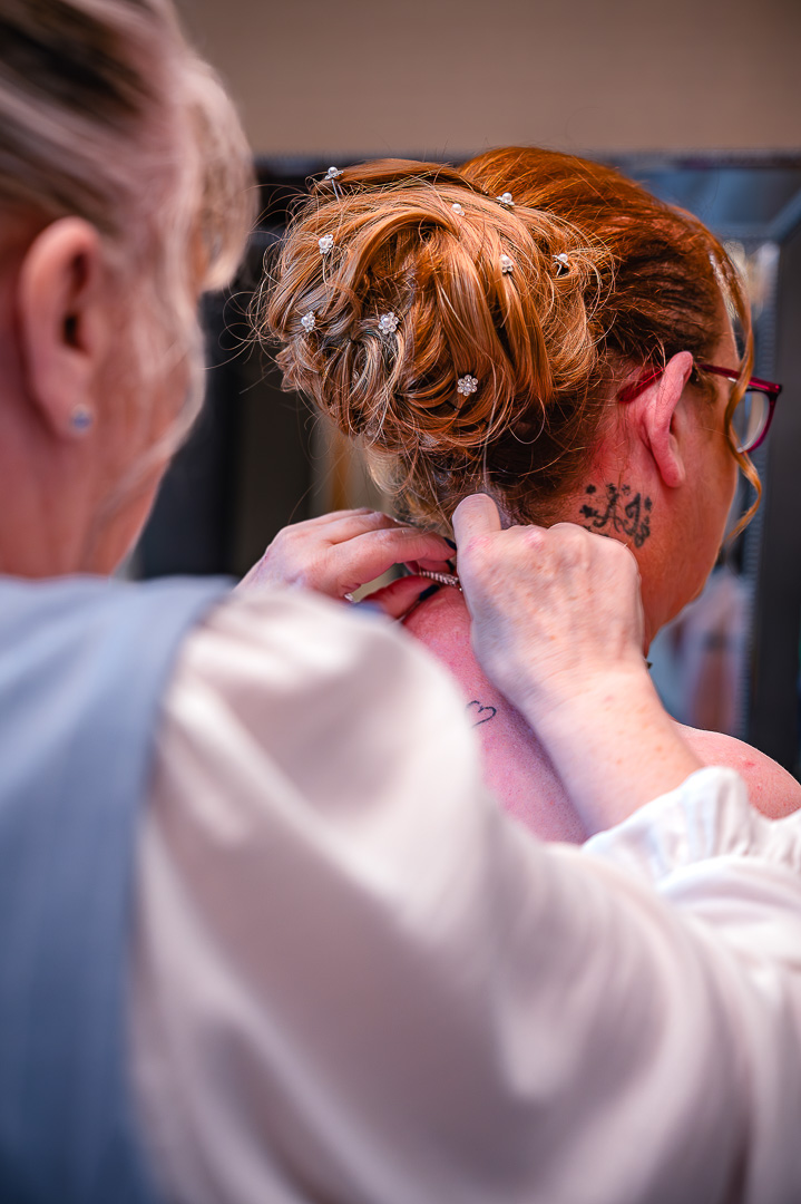 Bride’s necklace being clasped before departing for St Chad’s Church