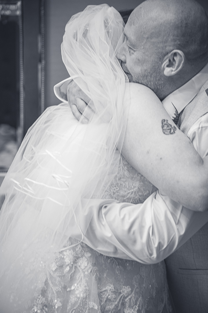 Bride sharing an emotional hug with her brother before leaving for the church ceremony