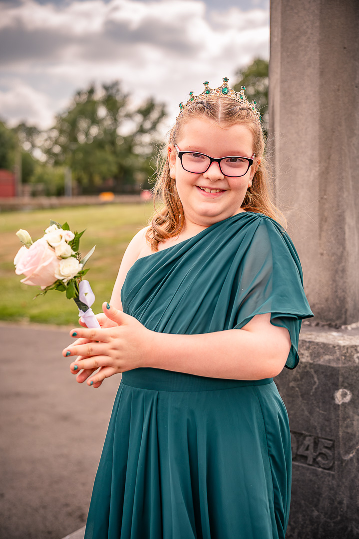 Young bridesmaid in a green dress waiting outside St Chad’s Church