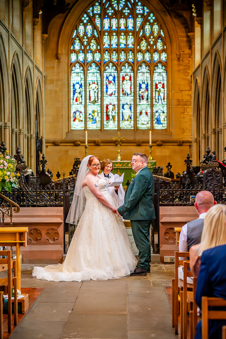 Bride smiling toward the congregation as vows are exchanged at St Chad’s Church