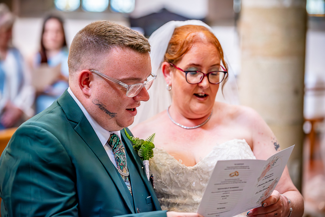 Bride and groom singing a hymn together during their Christian wedding ceremony