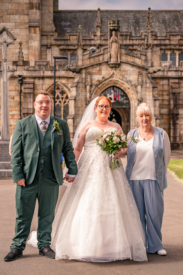 Bride and groom with the bride’s mother outside St Chad’s Church in Rochdale