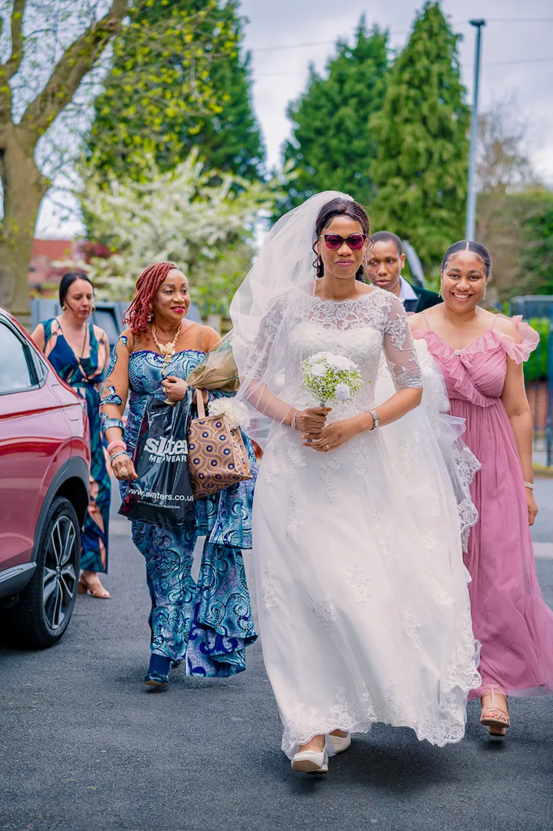 Bride heading inside William Hulme's Grammar School with her mother, sister and brother for her wedding blessing in Manchester