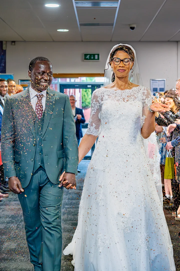 Couple during Confetti inside the foyer at William Hulme's Grammar School during Bea and Abraham's wedding blessing in Manchester