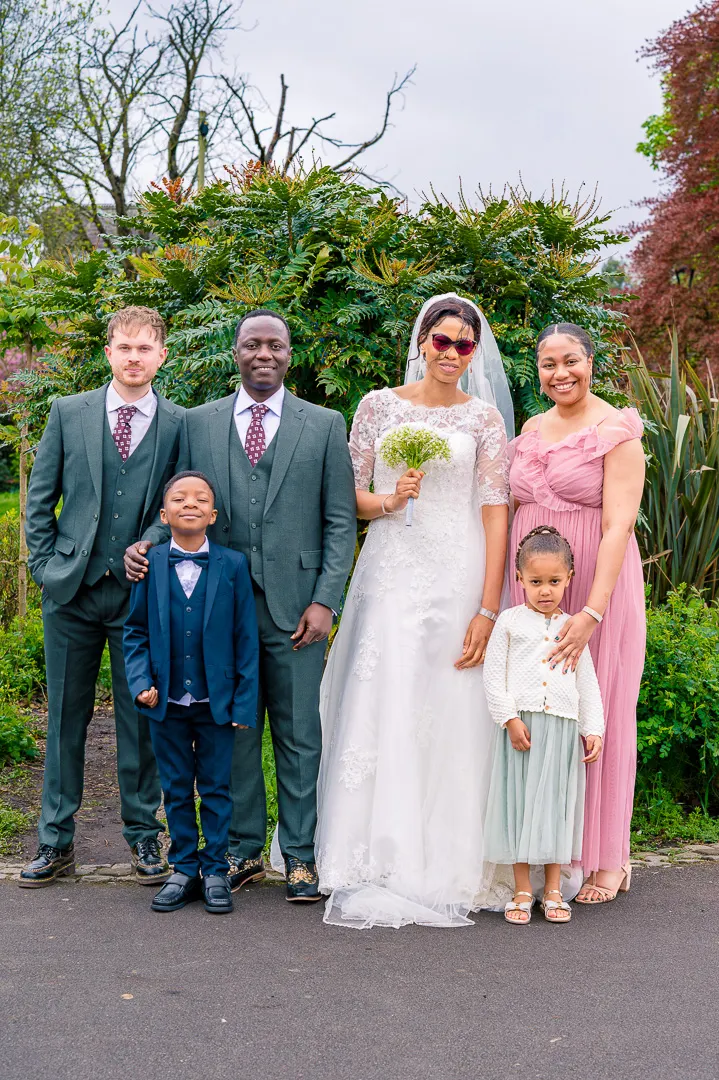 Portrait of Bride and Groom with their wedding party at Alexandra Park, Manchester, during Bea and Abraham's wedding blessing celebrations