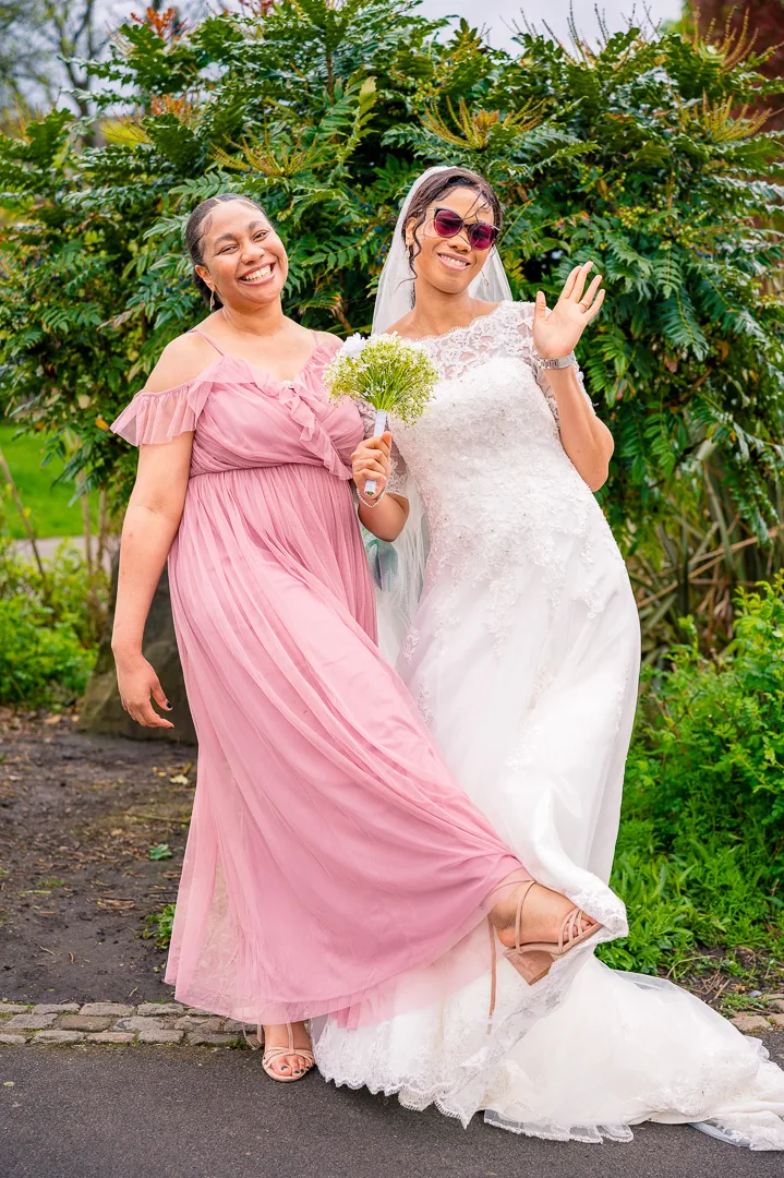 Portrait of laughter between bride and her sister (bridesmaid) at Alexandra Park, Manchester, during Bea and Abraham's wedding blessing celebrations