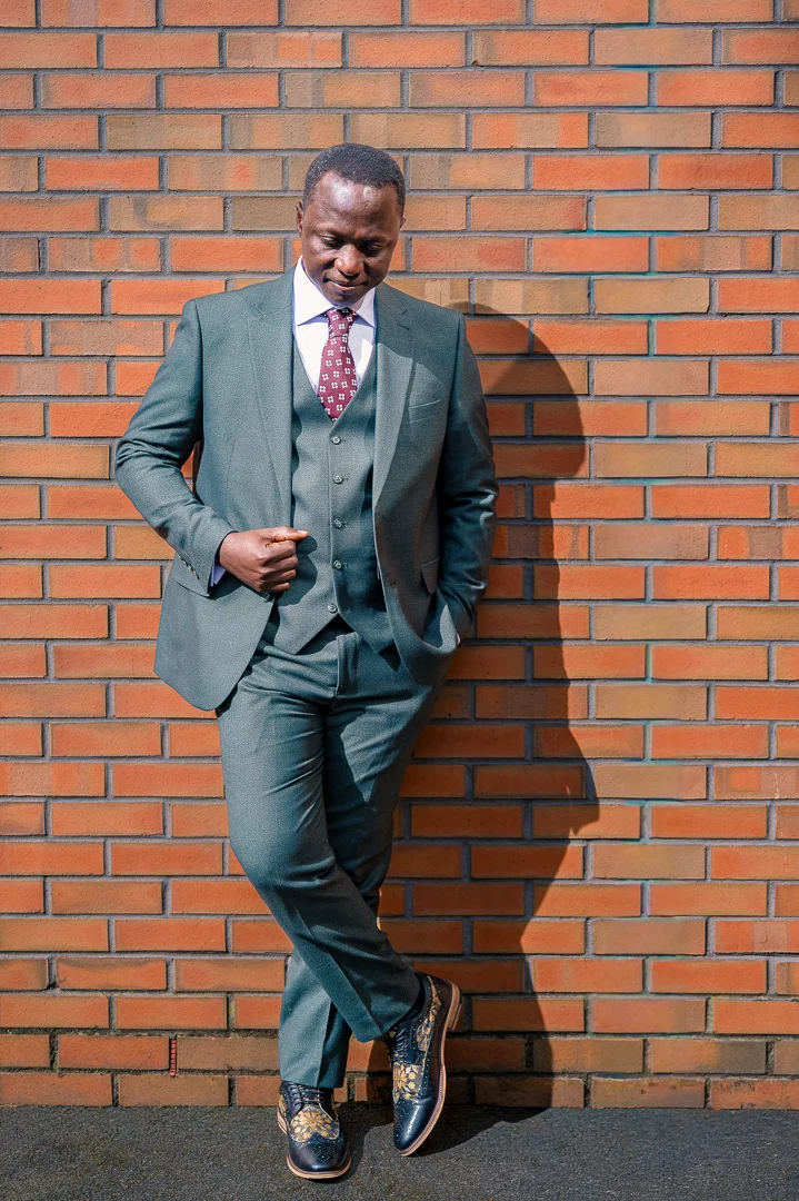 Groom taking a moment during his portraits taken at William Hulme's Grammar School before their wedding blessing in Manchester