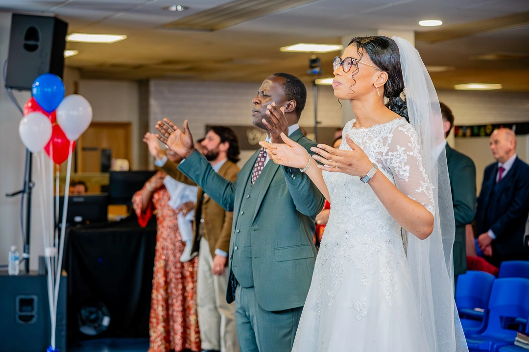 Couple worshiping as Manchester Vineyard worship band lead worship during Bea and Abraham's wedding blessing ceremony in Manchester