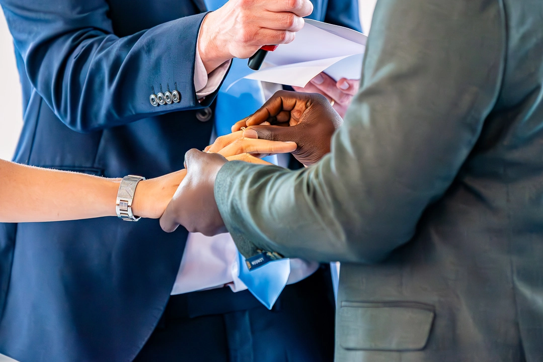 Bea and Abraham exchanging rings during their wedding blessing ceremony at William Hulme's Grammar School, Manchester