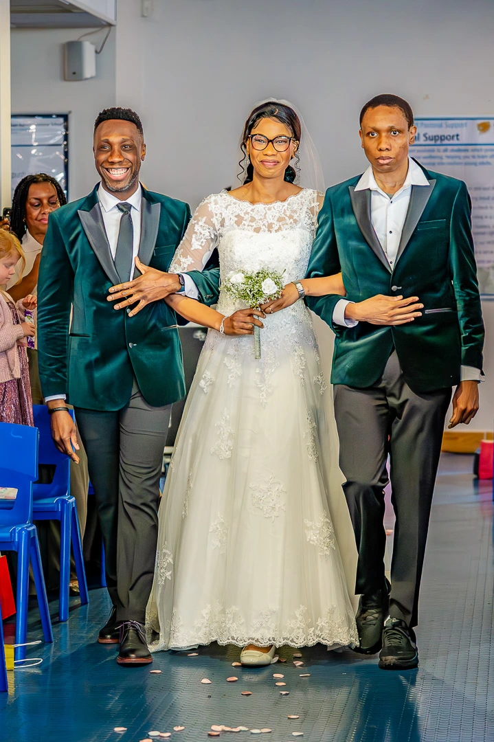 Bride been walked down the aisle with her brother at Wedding blessing ceremony at William Hulme's Grammar School, Manchester